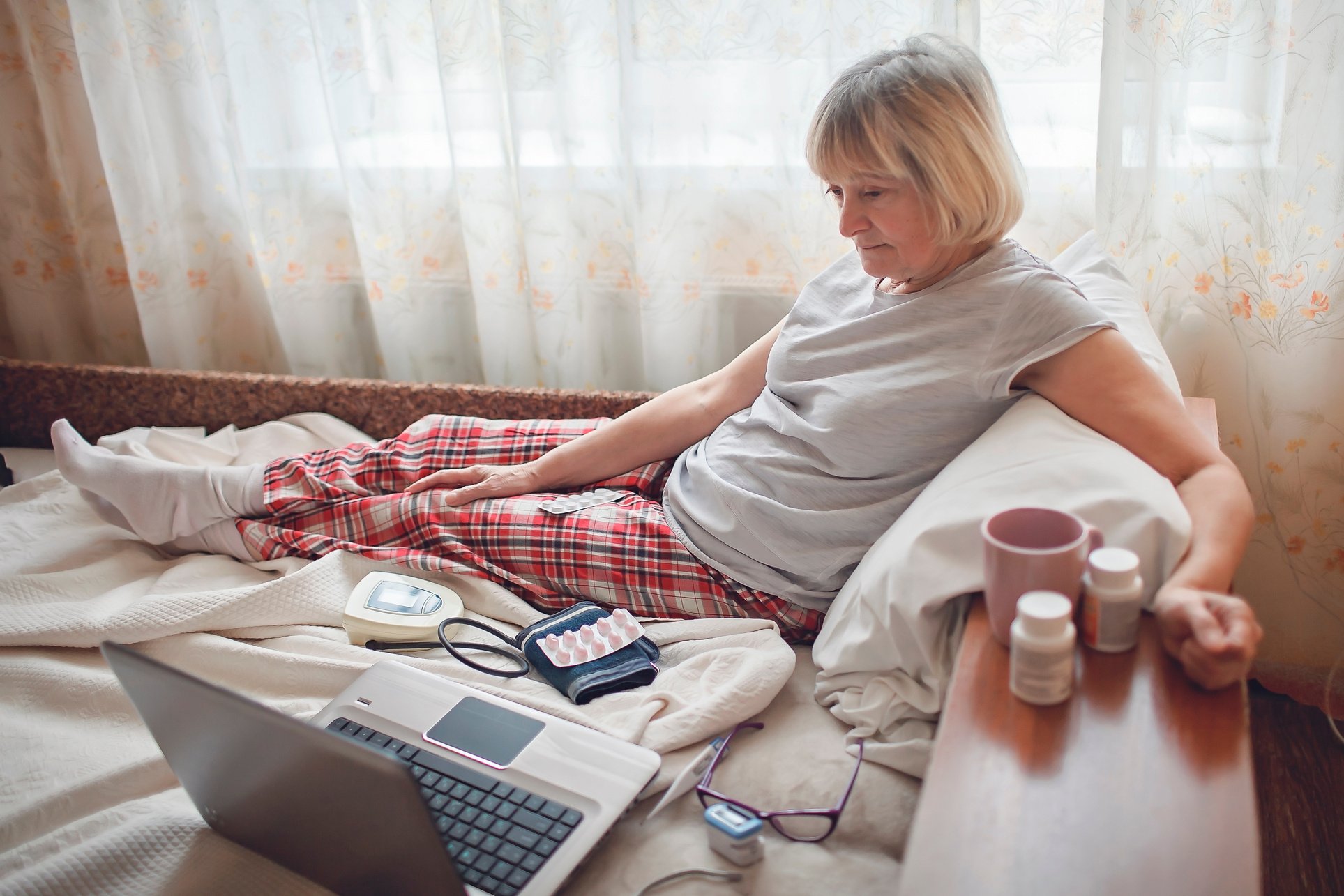 Old Woman in Bed Having Medical Teleconsultation